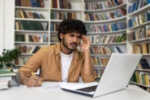 estudante concentrado em laptop ambiente moderno