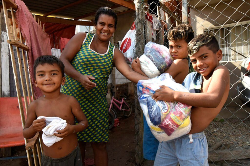 mae com bebe recebendo cesta de alimentos