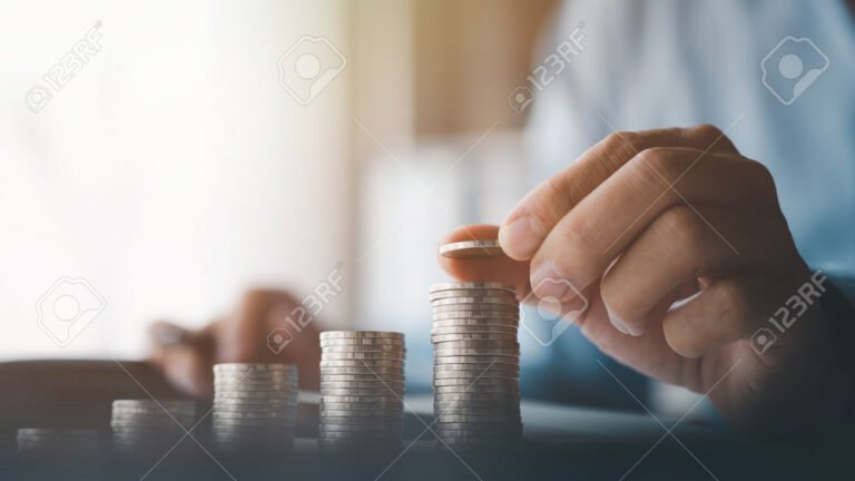 mao segurando moedas sobre documentos fiscais