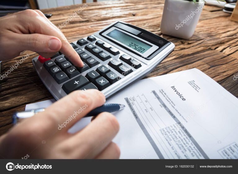 mao segurando uma calculadora sobre mesa