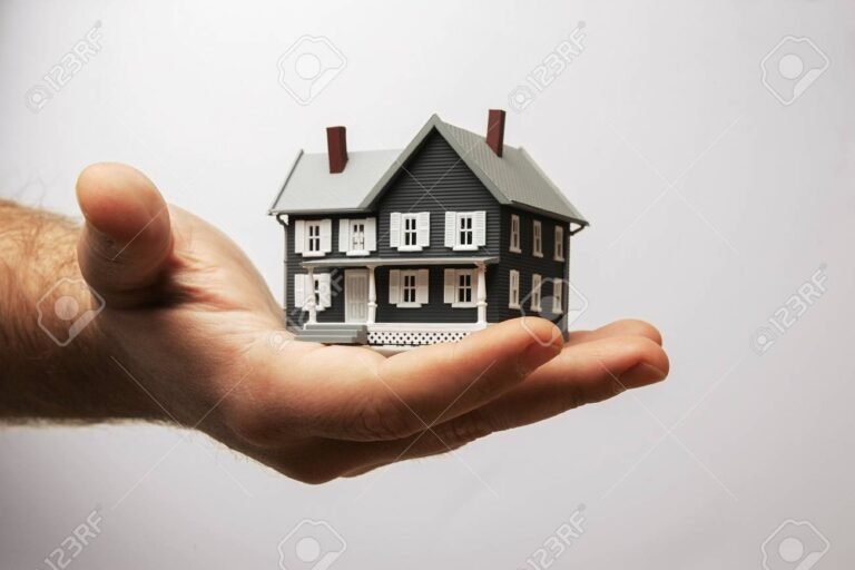 mao segurando uma casa em miniatura