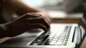 maos digitando em um teclado de computador