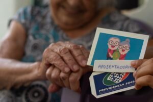 maos idosas segurando documentos de aposentadoria