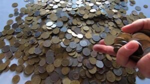 maos segurando moedas caindo em uma caixa