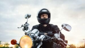 motociclista com viseira aberta em estrada