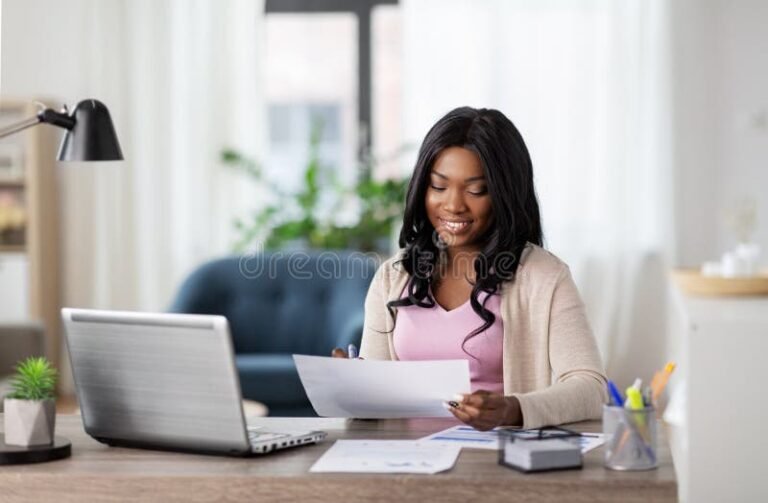pessoa sorridente com laptop e documentos