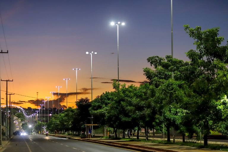 poste de luz iluminando uma rua a noite