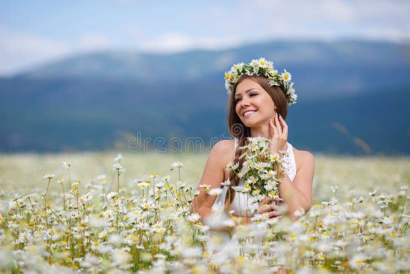 uma pessoa sorrindo em um campo florido